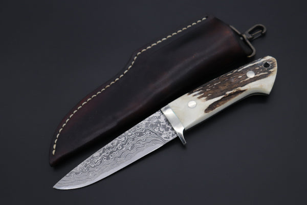 Handmade Damascus steel hunting knife with natural stag horn antler handle and dark brown leather sheath