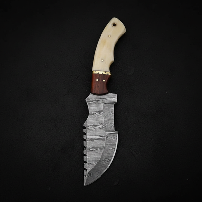 Damascus tracker knife with camel bone and rosewood handle on deep black charcoal background studio shot