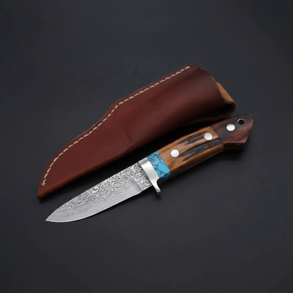 Handmade Damascus drop-point hunting knife with wood handle, turquoise spacer, and brown leather sheath on black-charcoal background