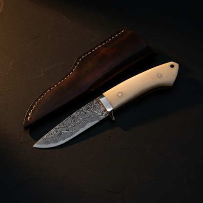 Damascus drop point knife with leather sheath in dark cinematic luxury editorial product photography