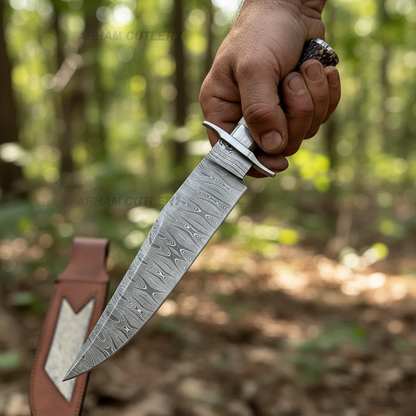 Rugged hand gripping handmade Damascus Bowie knife with stag antler handle, full blade visible