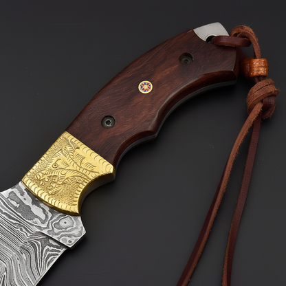 Close-up of rosewood scales, engraved brass bolster, mosaic pin, and leather lanyard on a black-charcoal background