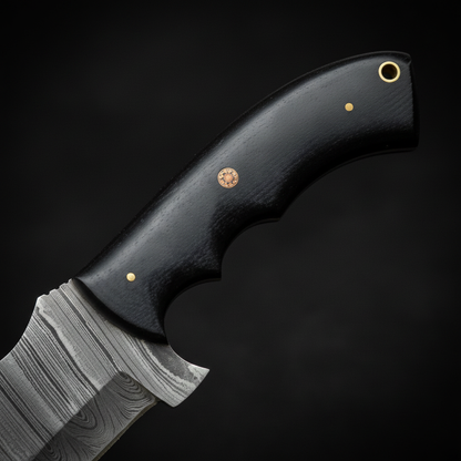 Close-up of smooth black micarta handle with brass pins and unique mosaic pin detail on black charcoal background