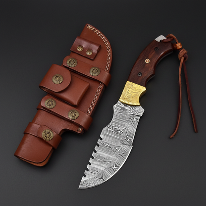 Damascus steel tracker hunting knife with rosewood handle and leather sheath on a black-charcoal studio background