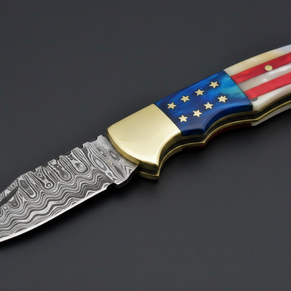 Close-up of the American flag resin and camel bone handle with brass accents on a black-charcoal background