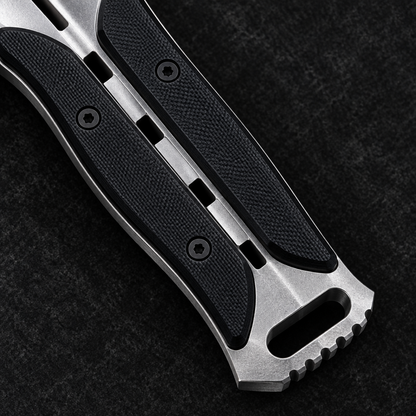 Extreme close-up of skeletonized full tang handle with black G10 scale inserts and integrated tactical pommel on deep black charcoal background